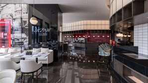 A modern restaurant with a bar area, seating with tables and chairs, and a polished marble floor. - Kew Green Hotel Hongqiao Shanghai (Shanghai)