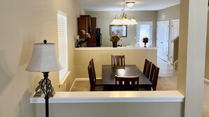 A dining area with a table and chairs, a lamp, and a ceiling light fixture. - Quiet and Beautiful House in a WONDERFUL location near 2 Lakes and Charlotte! (Huntersville)