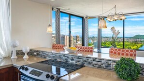 Una cocina con una isla grande, vistas de la ciudad y un comedor con mobiliario estampado.