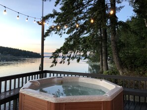 A hot tub on a deck with a view of a lake and trees. - Waterfront with Hot Tub PNW Cabin (Lakebay)