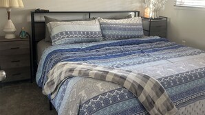 A bedroom with a bed, nightstands, a ceiling fan, wall art, and a window with blinds. - ReTreat yourself with this sunny A-frame experience (delta)
