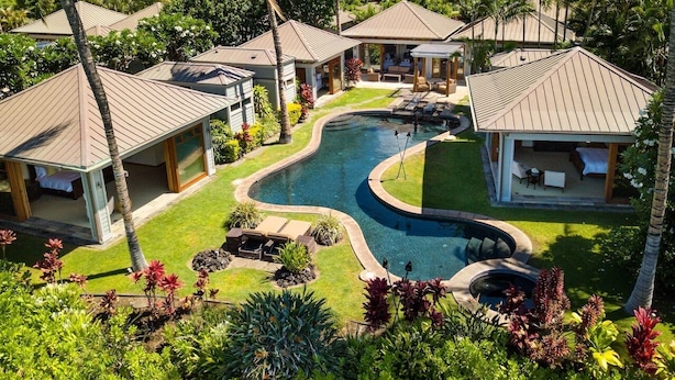 Un complexe hôtelier comprenant plusieurs villas, une piscine centrale et de magnifiques jardins tropicaux.