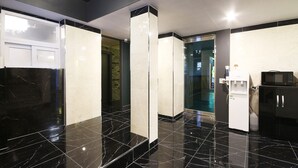 Eine moderne Küche mit schwarzen Marmorarbeitsplatten, einer eingebauten Mikrowelle und einem Wasserspender.
