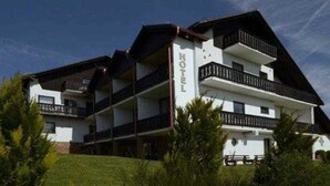 Un hotel de varios pisos con balcones y cielo despejado.