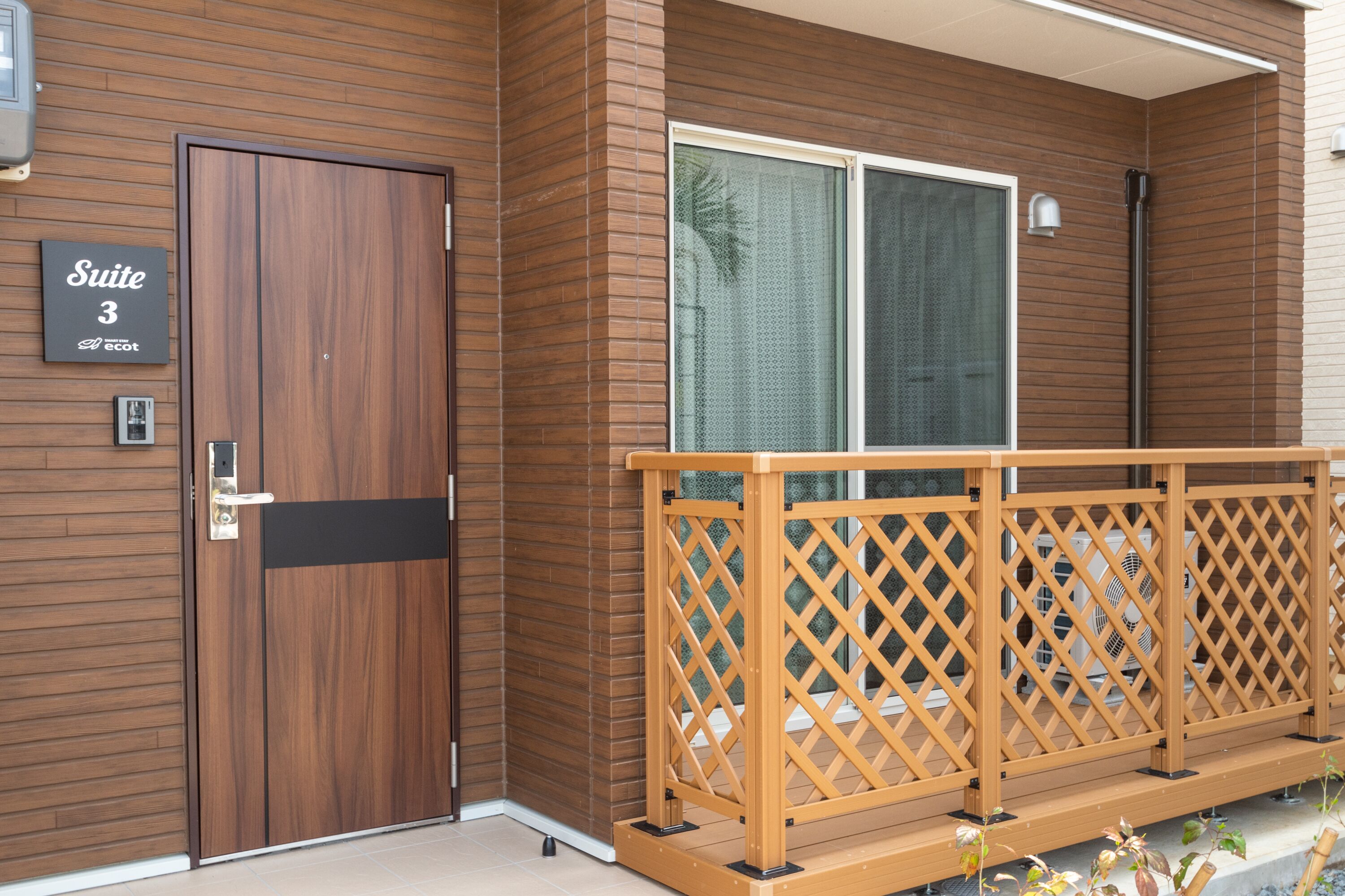 A wooden exterior with a sign reading "Suite 3" and a wooden balcony railing.