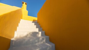 A staircase with white steps leading up to a yellow wall. - Bralos Villa - Paros - Near Naousa, spectacular sea views, 2 bedrooms, privacy (Paros)