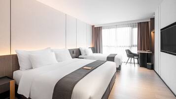 Una habitación de hotel moderna con dos camas, un escritorio y un televisor.