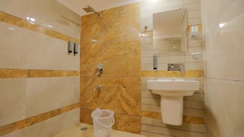 A modern bathroom with a marble wall, a sink, and a shower.