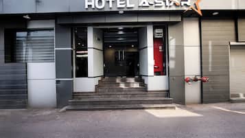 The entrance to HOTEL A-STAR with a modern design, featuring a prominent star logo above the entrance.