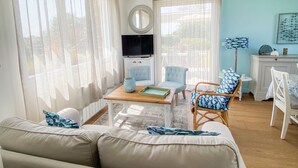 A living room with a sofa, two armchairs, a coffee table, and a TV. - Villa Espérance, a stone's throw from Barneville beach, rated 3 ***. (Saint-Jean-de-la-Rivière)
