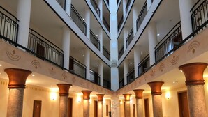A multi-level atrium with a pool table, columns, and a statue. - Aparthotel Poseidon - All inclusive (Sunny Beach)