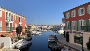 Un puerto deportivo con barcos amarrados, rodeado de edificios con balcones y ventanas arqueadas.