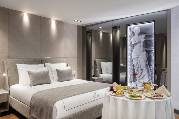 A modern hotel room with a large bed, a dining table with breakfast, and a large artwork on the wall. - Melas Hotel Istanbul (Istanbul)