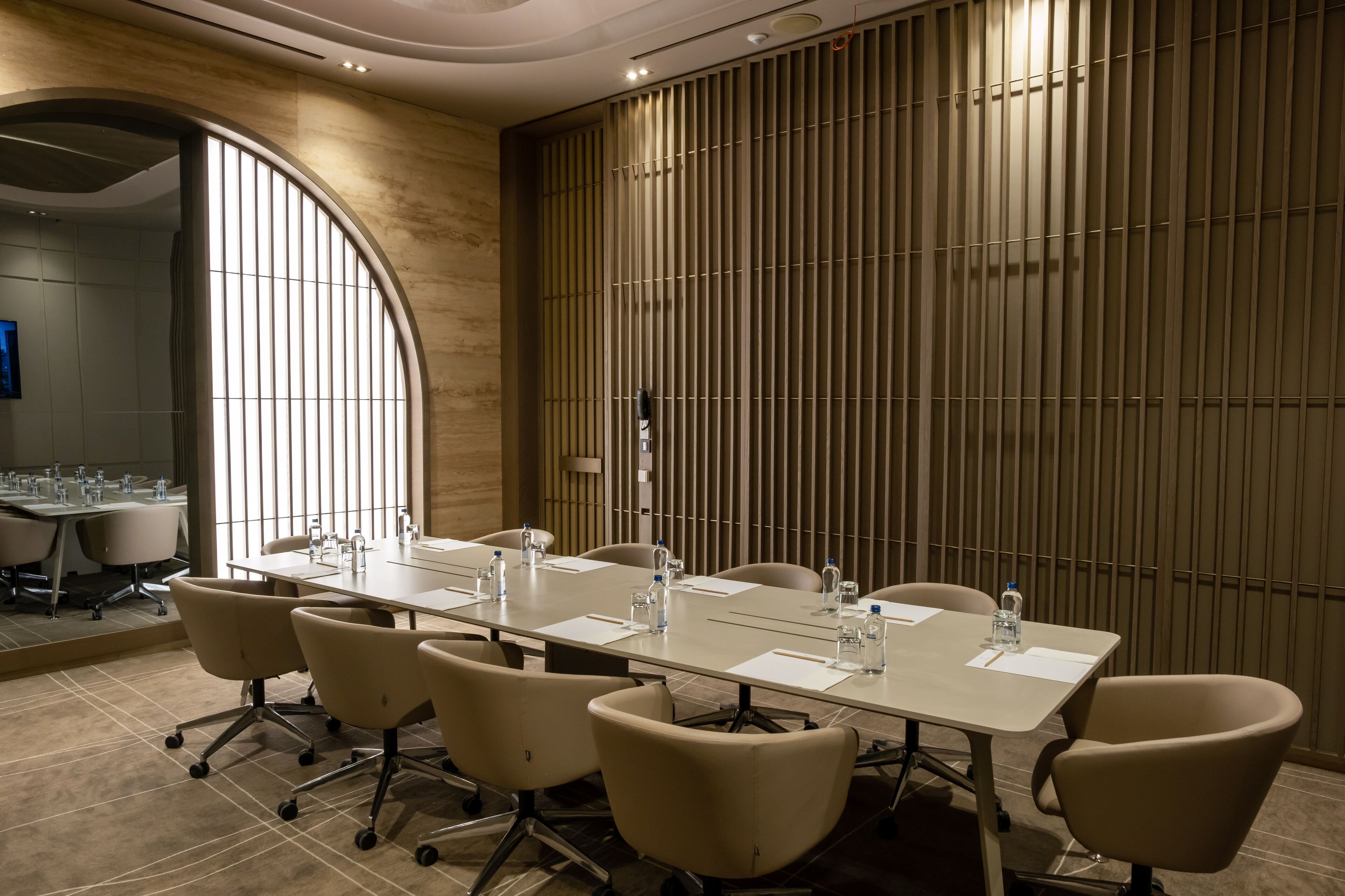 Une salle de conférence avec une longue table, six chaises et une grande fenêtre.