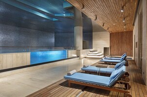 Una piscina techada, sillones reclinables de piscina