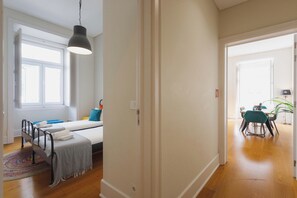 A room with a bed, bedside table, and a window. There is a door leading to another room. - Basil Red Apartment, AC, Wifi !new! (Lisboa)