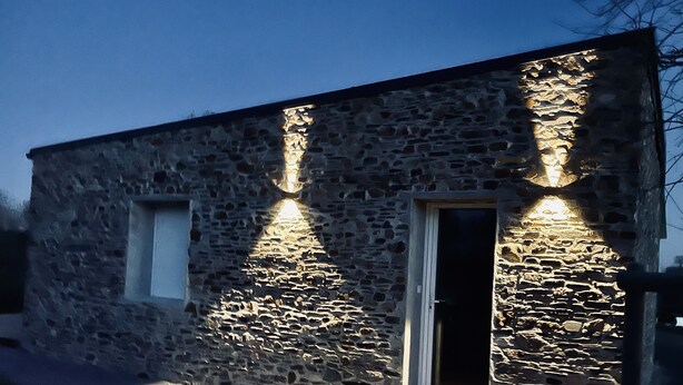 Un edificio de piedra con puerta de madera y una ventana pequeña.