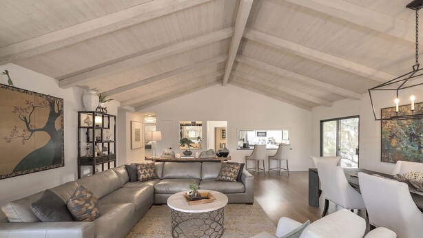 A spacious living room with a high ceiling, a sectional sofa, a round coffee table, and a dining area with white chairs. - 3819 Casa Carmela - Private Home in Carmel (Carmel)