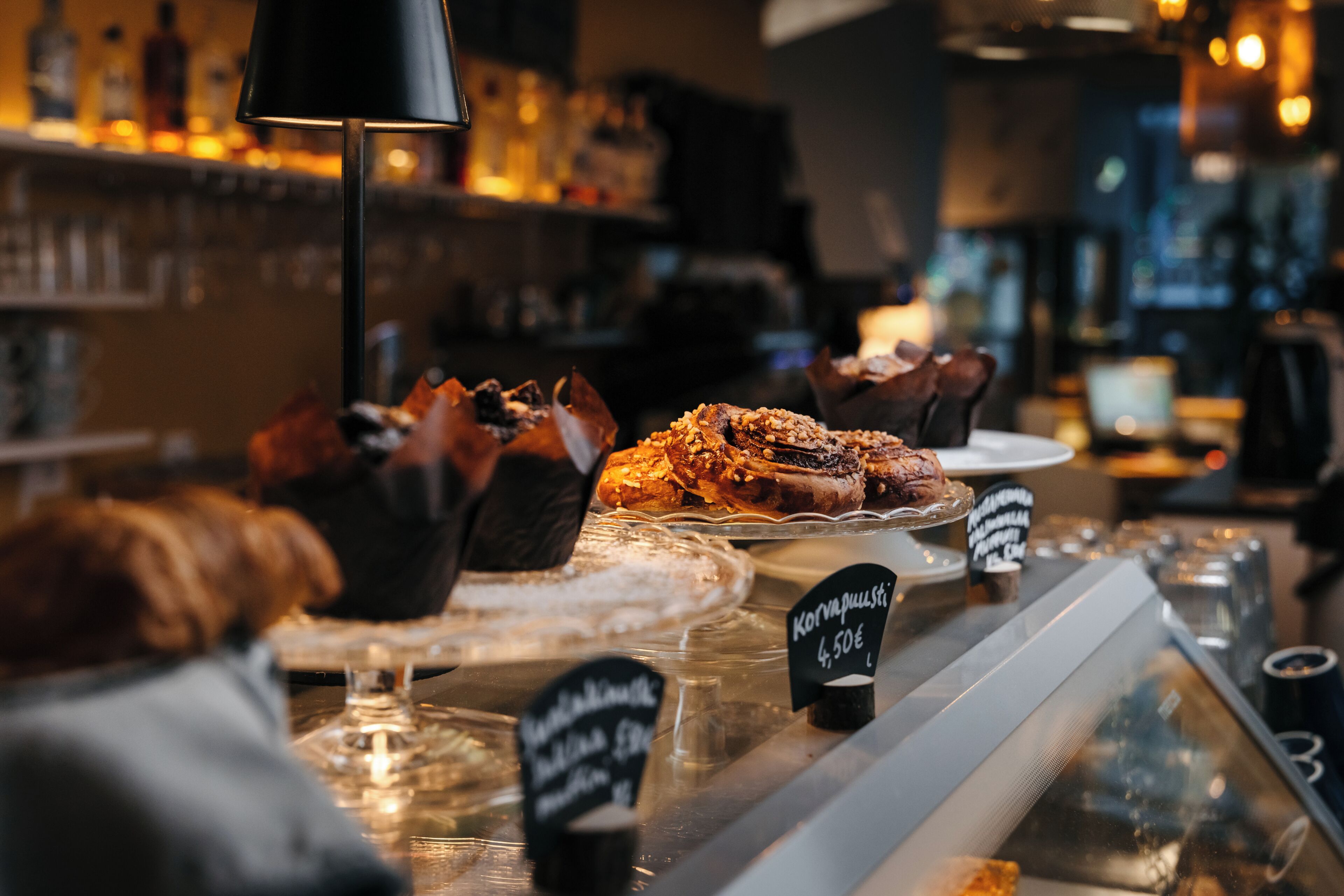 A bakery display with various baked goods and a price sign.
