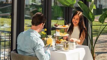 Un tavolo da pranzo con una tovaglia bianca, un vassoio di cibo e una macchina per il caffè.