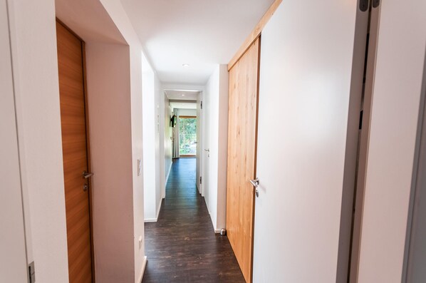 A hallway with wooden doors and a dark wooden floor. - Chalet Max Panorama by we rent (Zell am See)