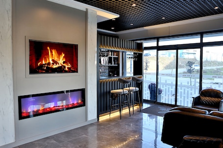 A modern interior with a fireplace, bar area, and seating.