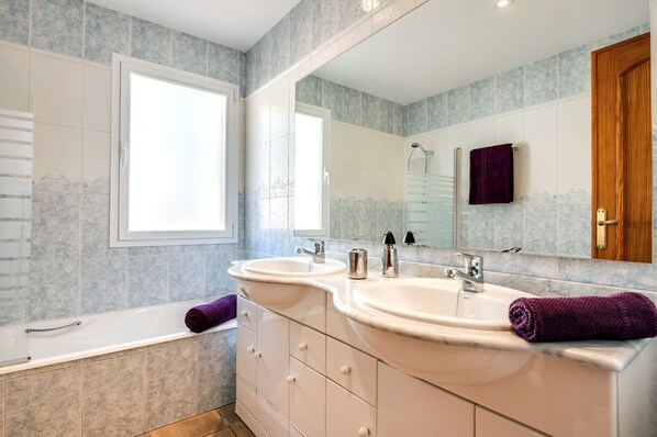 A bathroom with two sinks, a bathtub, a large mirror, and a window. - 3380 Villa Portichol Mar Flores (Moraira)