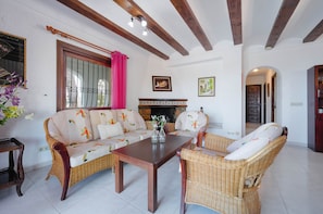 A living room with a sofa set, a coffee table, and a fireplace.