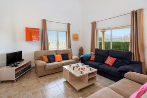 Ein Wohnzimmer mit zwei Sofas, einem Couchtisch und einer TV-Konsole.