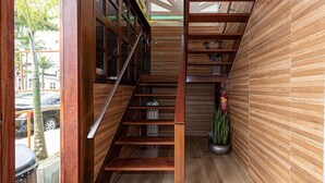 A wooden staircase with a metal railing, leading to a lower level. - Pousada Flor de Lótus (Ubatuba)
