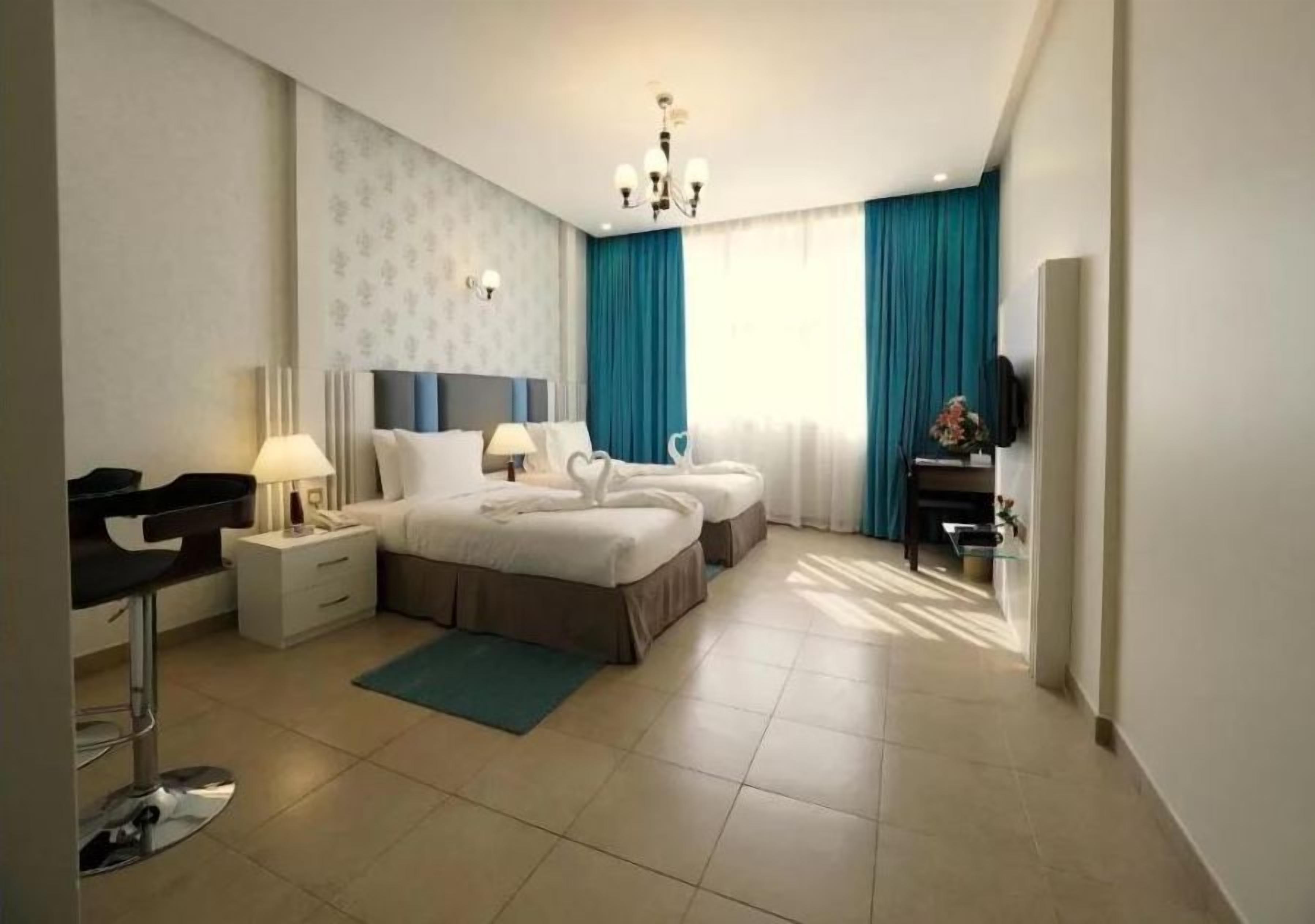 A modern hotel room with a large bed, two bedside tables, a desk, and a chair.