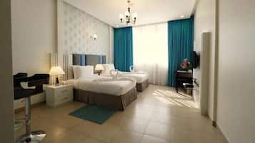 Quarto de hotel moderno com uma cama grande, duas mesas de cabeceira, uma escrivaninha e uma cadeira.