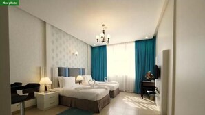 A modern hotel room with a large bed, two bedside tables, a desk, and a chair. - Skylark Hotel Apartments (Dubai)