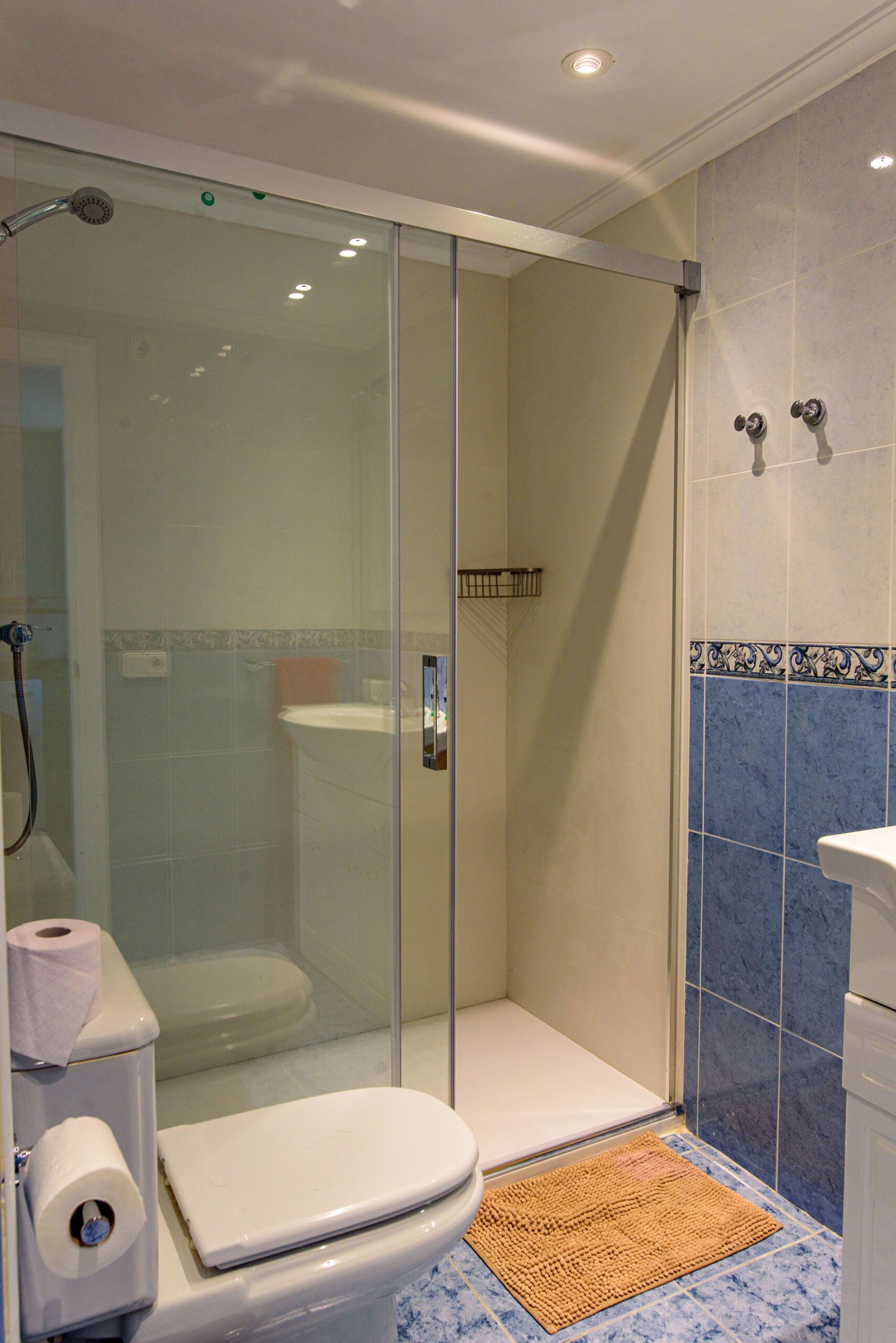 Ein modernes Badezimmer mit einer Duschkabine, einer Toilette und einem Waschbecken.
