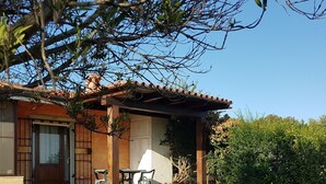 Ein Haus mit einer Terrasse, einem Esstisch und Stühlen.