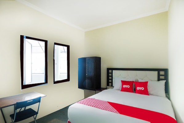 A hotel room with a bed, two windows, a desk, and a wardrobe. - Super OYO 3354 Homia Residence (South Tangerang)
