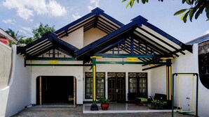 A building with a covered entrance, a swing set, and potted plants. - OYO 3301 Pondok Eyang Obi (Sleman)