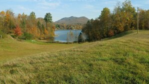 A grassy field with a lake and mountains in the background. - Lake Eden/Expansive Multi-Level (Eden)