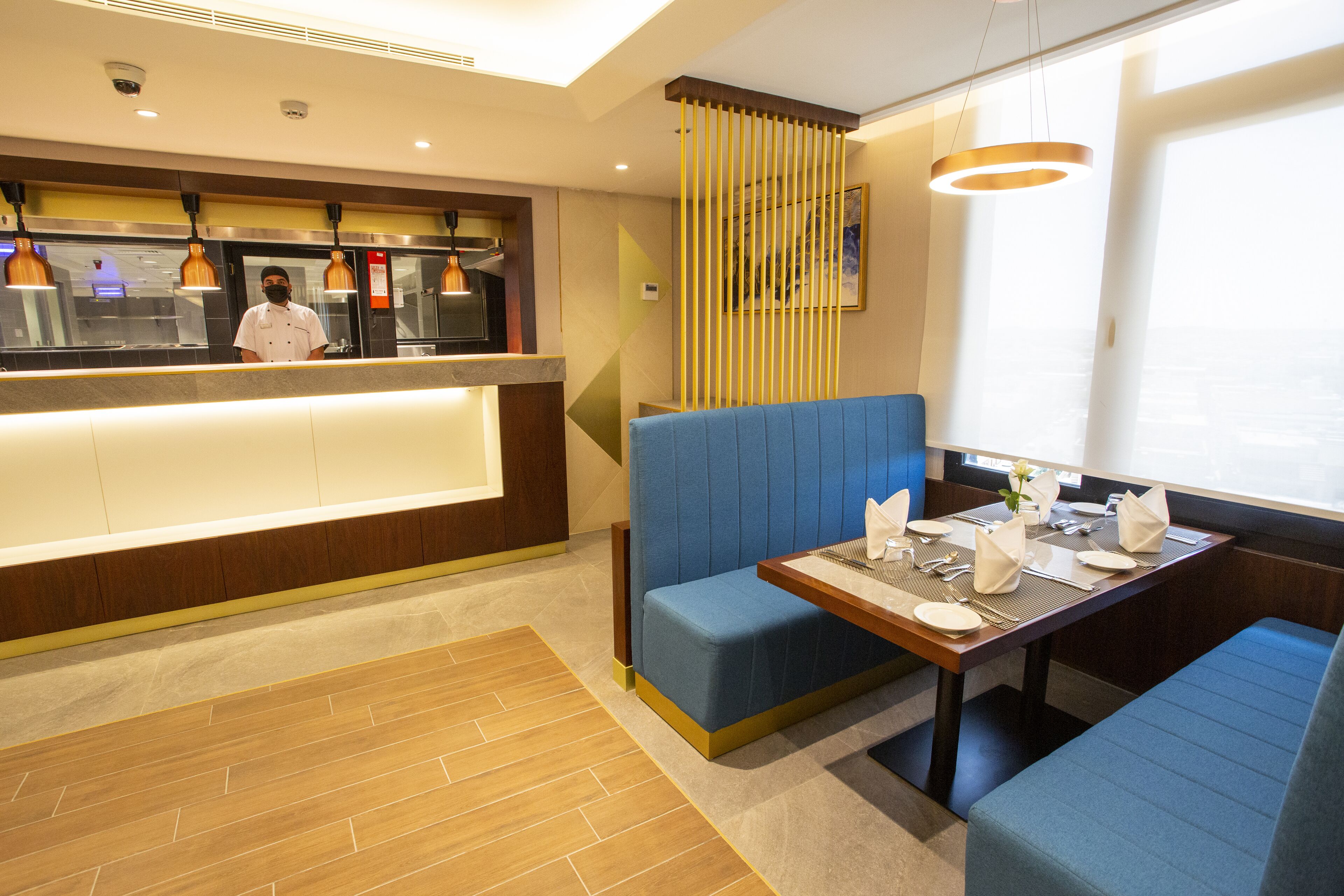A restaurant interior with a counter, seating area, and a view of the sea.