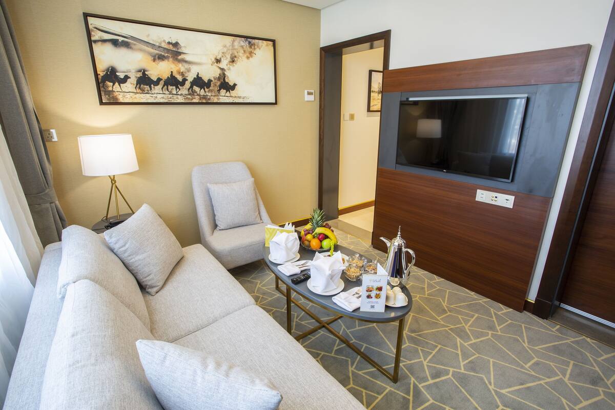 Een hotelkamer met een bank, fauteuil en een bijzettafeltje met voorzieningen.