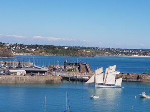 A coastal marina with sailboats, a pier, and a building with a sloped roof. - Spacious house in Yquelon with enclosed garden and internet, near Granville (Yquelon)