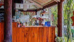 Een houten bar met een krijtbordmenu, verschillende flessen en een bord.