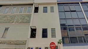 A hotel building with multiple windows, air conditioning units, and a sign indicating a 4001 room. - OYO 4001 Kalideres Residence Syariah (Jakarta)