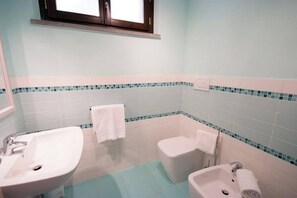 Ein Badezimmer mit zwei Waschbecken, einer Toilette und einer Badewanne.