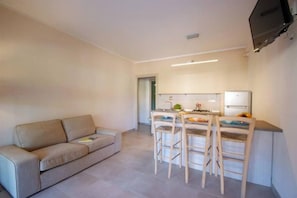 Ein Wohnzimmer mit einer Couch und einem Essbereich mit Tisch und Stühlen.