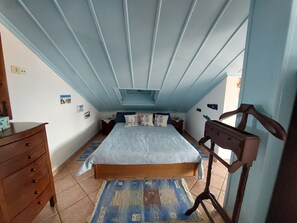 A bedroom with a bed, dresser, and a desk.