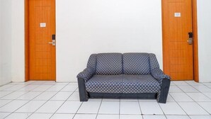 A room with two wooden doors, each marked with a number. A patterned sofa is centered in the room. - Spot ON 3075 Griya Sae Guesthouse (Kendal)