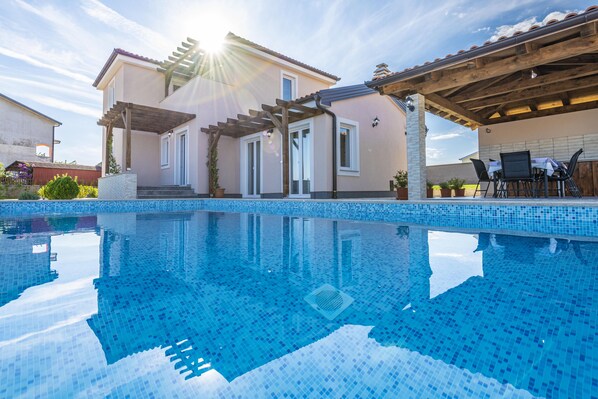 A swimming pool with a house in the background.