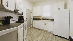 A kitchen with white cabinets, a wooden countertop, and a built-in oven.