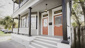 A two-story house with a porch, steps, and a mailbox.